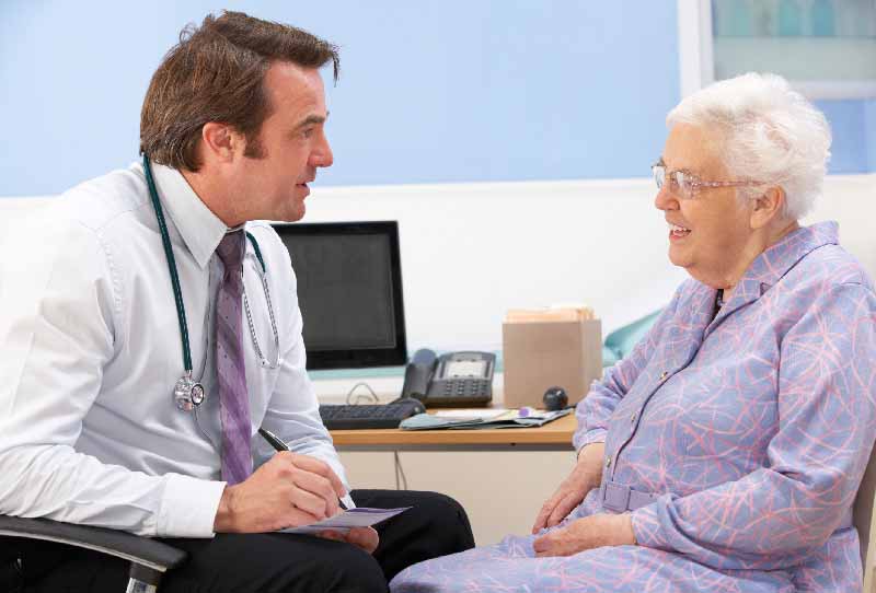 Idősebb betegnek tanácsot adó orvos